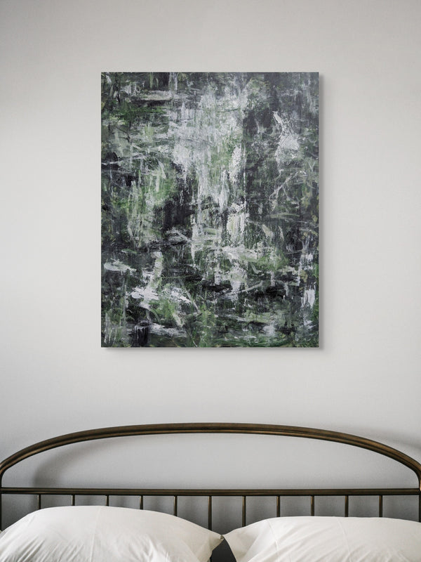 a large abstract painting hanging on a wall above a bed with a metal headboard.